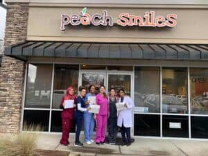 Peach smiles team in front of their building